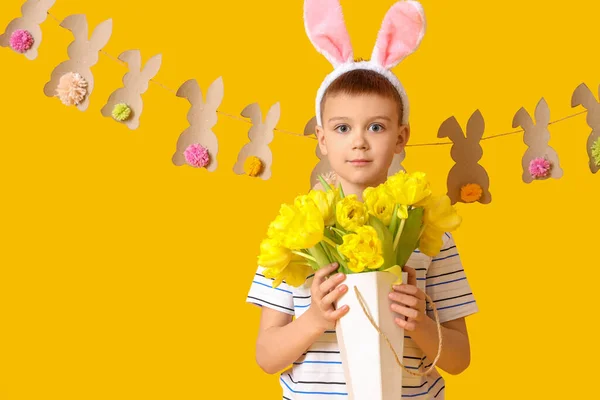 Schattig Jongetje Met Konijntjes Oren Bloemen Gele Achtergrond Pasen Viering — Stockfoto
