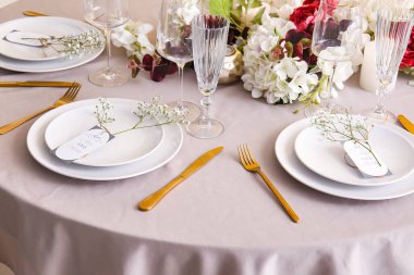 Düğün davetiyeleriyle süslü masa dekorları ve gypthe çiçekleri.