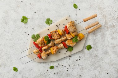 Hafif arka planda sebzeli ızgara tavuk şişleri.