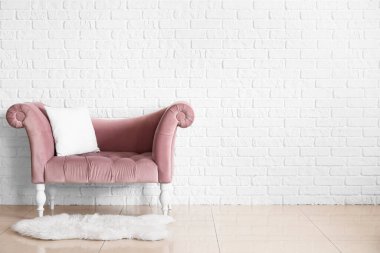 Beyaz tuğla duvarın yanındaki şık kanepe