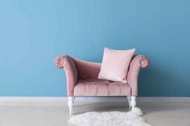 Mavi duvarın yanındaki şık pembe kanepe