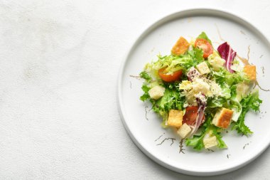 Beyaz arka planda lezzetli vegan Sezar salatası tabağı, yakın plan.