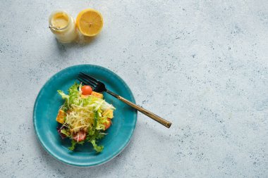Hafif arka planda bir tabak lezzetli vegan Sezar salatası.