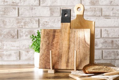 Tahta kesme tahtaları ve ekmek tuğla duvarın yanındaki masada.