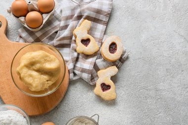 Taze hamurlu kase ve gri arka planda lezzetli Paskalya kurabiyeleri.