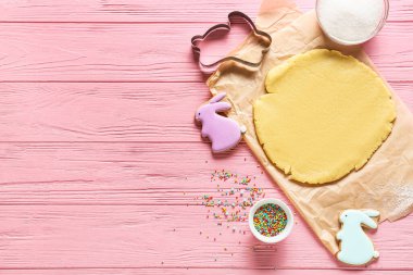 Pembe ahşap arka planda Paskalya kurabiyeleri hazırlamak için taze hamur.
