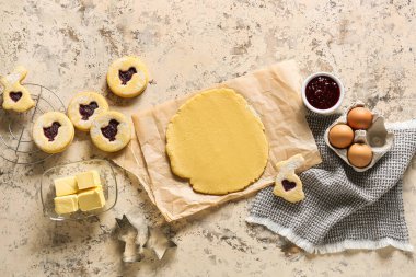 Bej arka planda Paskalya kurabiyeleri hazırlamak için taze hamur ve malzemeler