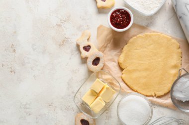 Hafif arka planda Paskalya kurabiyeleri hazırlamak için taze hamur ve malzemeler