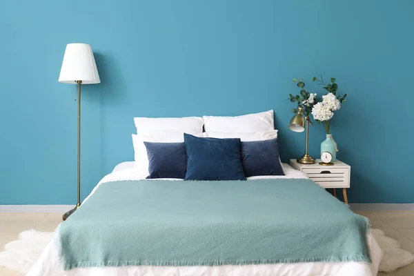 Rahat Bir Yatak Komodinin Üstünde Çiçekli Vazo Mavi Duvarın Yanında — Stok fotoğraf