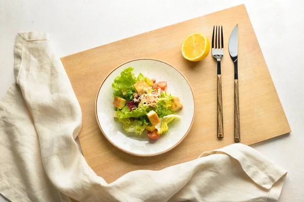 Beyaz arka planda bir tabak lezzetli vegan Sezar salatası.