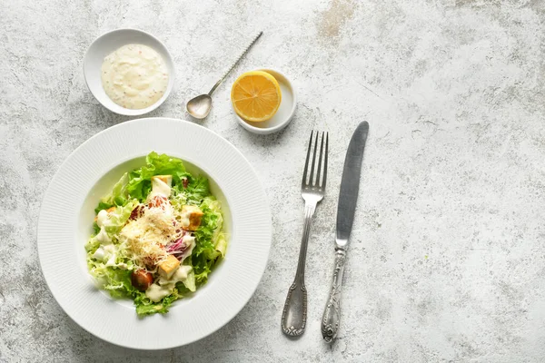 Plate of tasty vegan Caesar salad on light background