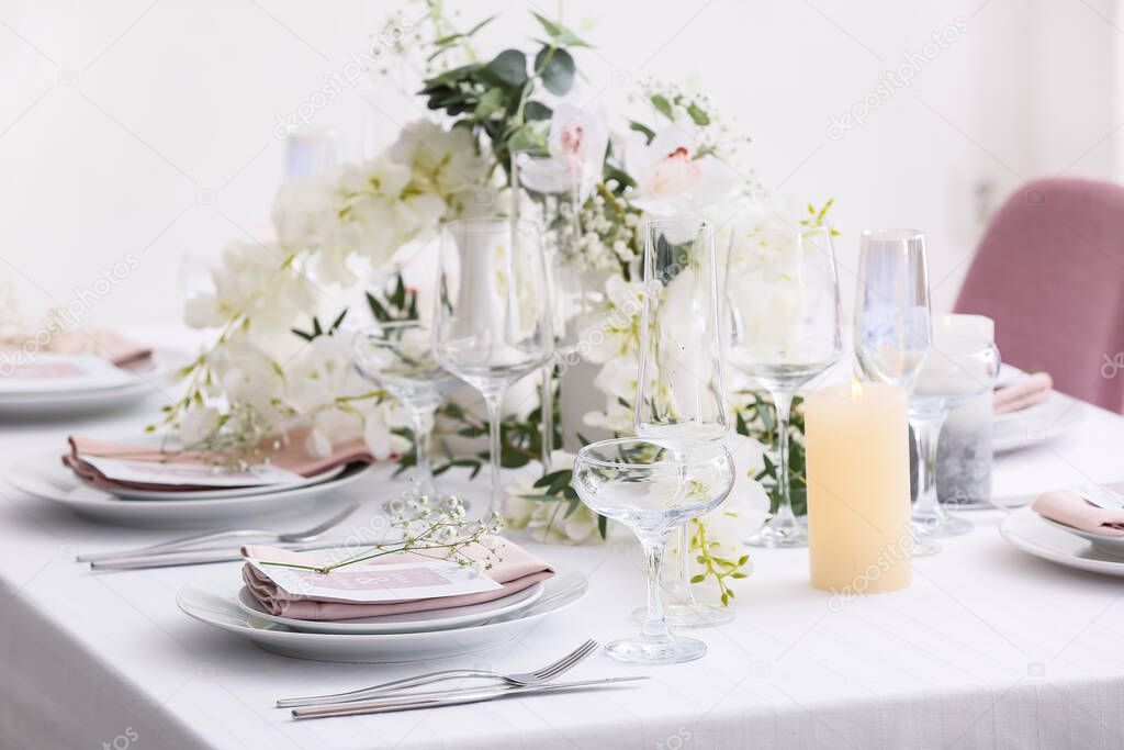 Stylish table setting with wedding invitations and gypsophila flowers