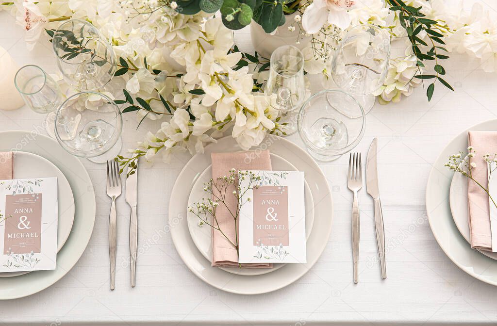 Stylish table setting with wedding invitations and gypsophila flowers, top view