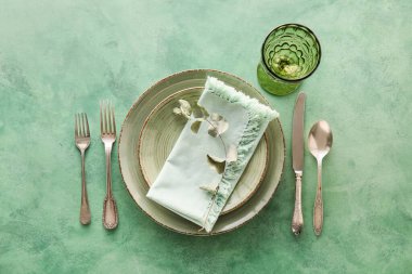 Yeşil zemin üzerinde okaliptüs yaprakları olan zarif masa ayarı