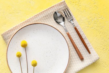 Zarif bir masa ve sarı arka planda çiçekler.