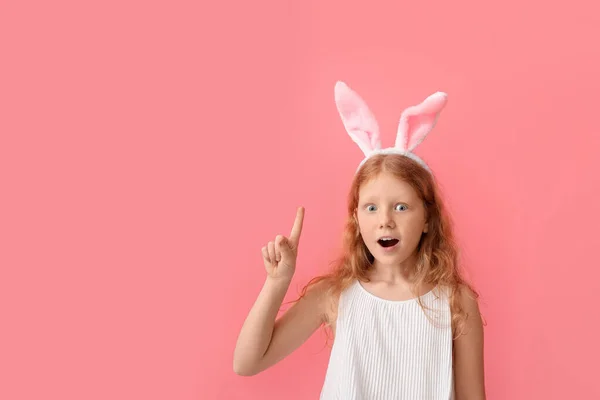 ウサギの耳を持つ面白い赤毛の女の子と色の背景に人差し指を上げました イースターのお祝い — ストック写真