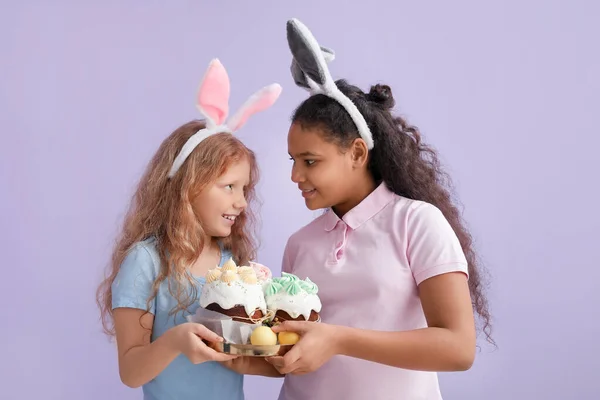 Nette Kleine Mädchen Mit Hasenohren Ostereiern Und Kuchen Auf Farbigem — Stockfoto