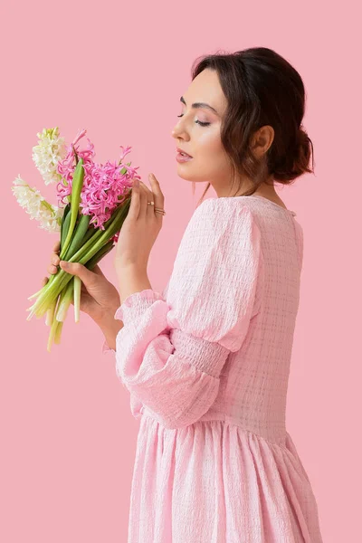Pembe Arka Planda Sümbül Çiçekleri Olan Güzel Genç Bir Kadın — Stok fotoğraf