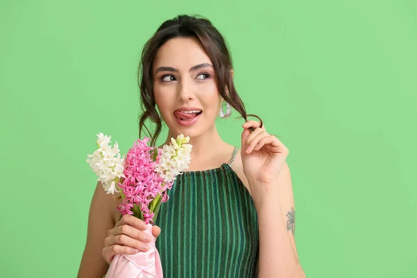 緑の背景にヒヤシンスの花を持つかなり若い女性 — ストック写真