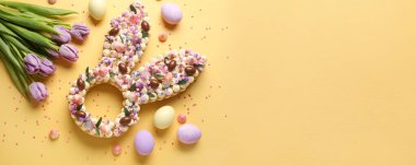 Sarı arkaplanda Paskalya kutlaması için güzel bir pasta ve metin için yer var.