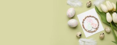 Yeşil arka planda tebrik kartı, yumurta ve çiçekli güzel bir Paskalya kompozisyonu.