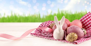 Paskalya yumurtaları ve dışarıdaki masada duran tavşan heykelciği.