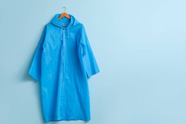 Mavi duvarda asılı yağmurluk