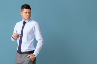 Resmî giyinmiş yakışıklı adam renk geçmişine bakıyor.