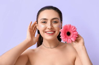 Yaratıcı makyajlı gülümseyen kadın ve arkaplanda gerbera çiçeği