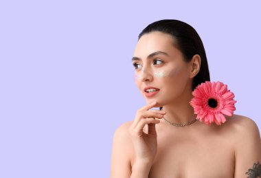 Yaratıcı makyajlı ve Gerbera çiçekli bir kadın.