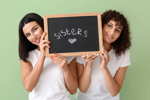Jóvenes Mujeres Sonrientes Sosteniendo Tablero Con Palabra Sisters Fondo Color — Foto de Stock
