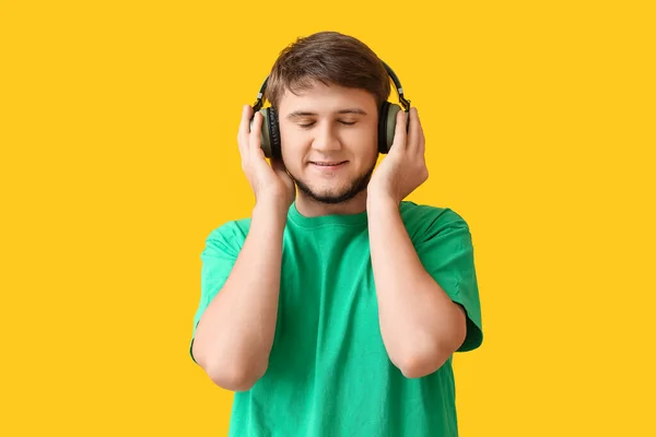 Joven Escuchando Música Sobre Fondo Amarillo — Foto de Stock