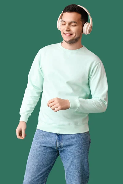 Joven Con Auriculares Inalámbricos Escuchando Música Sobre Fondo Verde —  Fotos de Stock