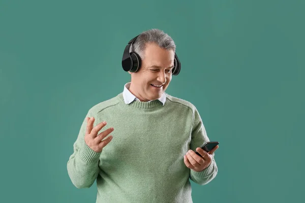 Senior Man Hoofdtelefoon Met Behulp Van Mobiele Telefoon Groene Achtergrond — Stockfoto