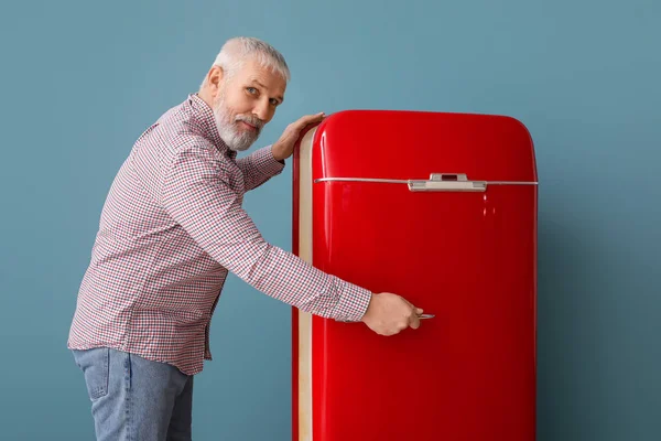 Mature Homme Ouverture Rouge Réfrigérateur Sur Fond Bleu — Photo