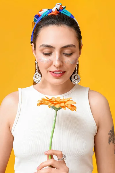 Kvinna Med Kreativ Makeup Och Eleganta Smycken Tittar Gerbera Blomma — Stockfoto