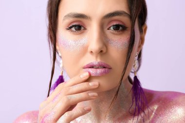 Yüzünde ve vücudunda renkler olan güzel genç bir kadın.