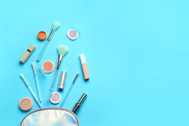 Mavi arka planda makyaj fırçaları ve kozmetik ürünleri ile kompozisyon