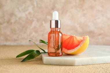 Arkaplanda bir şişe greyfurt yağı bulunan tahta