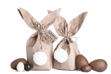Paskalya tavşanı hediye paketleri ve beyaz arka planda izole edilmiş çikolata yumurtaları.