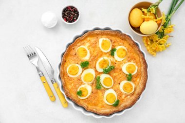 Lezzetli Paskalya turtası, boyalı yumurta, çatal bıçak takımı ve çiçekli kompozisyon