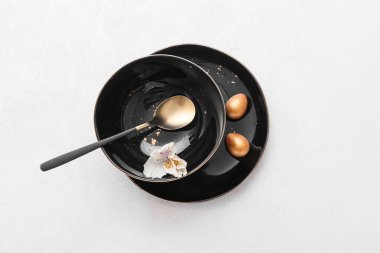 Beyaz arka planda Paskalya yumurtaları ve zambak çiçekli masa ayarı