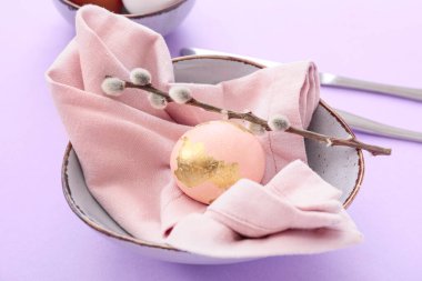 Paskalya yumurtası, söğüt dalı ve eflatun kaplama peçete, yakın plan.