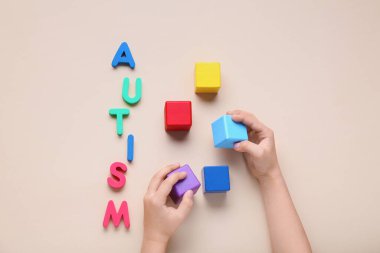 Bej arkaplan üzerinde küp ve kelime AUTISM olan çocuk