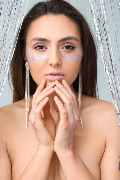 Vacker Ung Kvinna Med Glitter Ansiktet Mot Ljus Bakgrund — Stockfoto