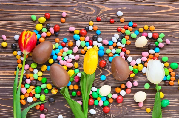 Composición Con Huevos Pascua Chocolate Caramelos Flores Sobre Fondo Madera — Foto de Stock