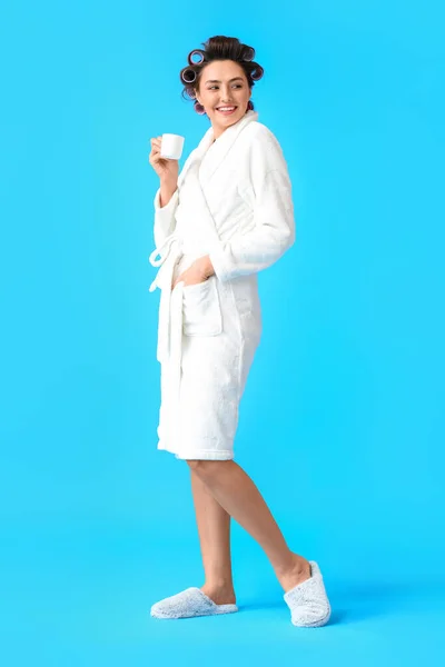 Beautiful Young Woman Bathrobe Hair Curlers Drinking Coffee Blue Background — Stock Photo, Image
