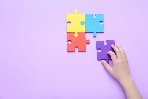 在紫丁香背景上有拼图的孩子 自闭症的概念 — 图库照片