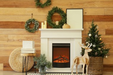 İçinde şömine ve Noel süsleri olan modern bir oda.