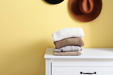 Sarı duvarın yanındaki klozette bir yığın kalın kazak.